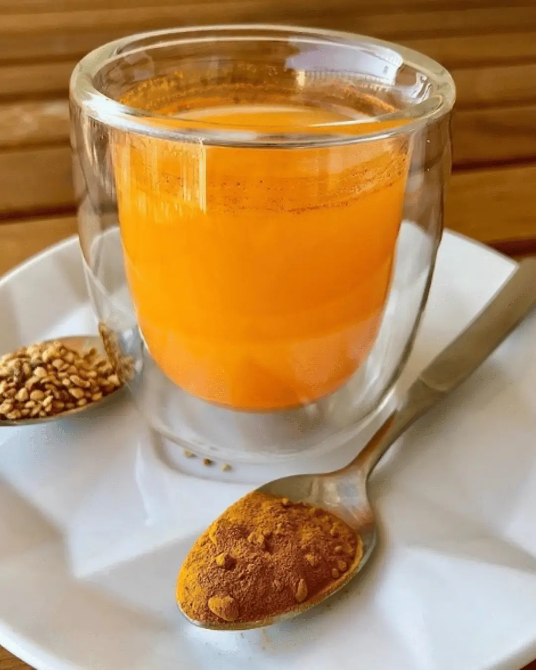 Shot matinal de cúrcuma e laranja servido em copo pequeno