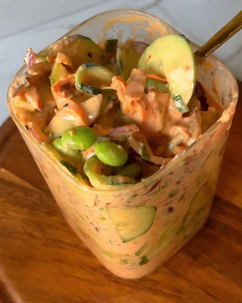Salada com edamame e molho especial cor de tomate no pote