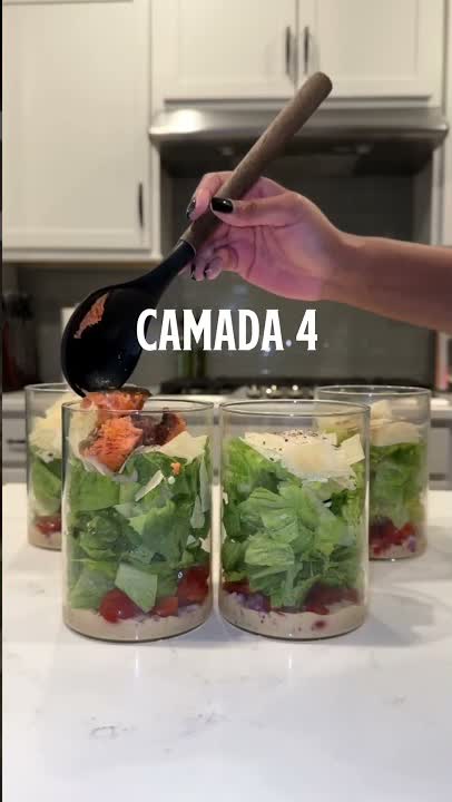 Molho sendo colocado como quarta camada em potes de salada caesar
